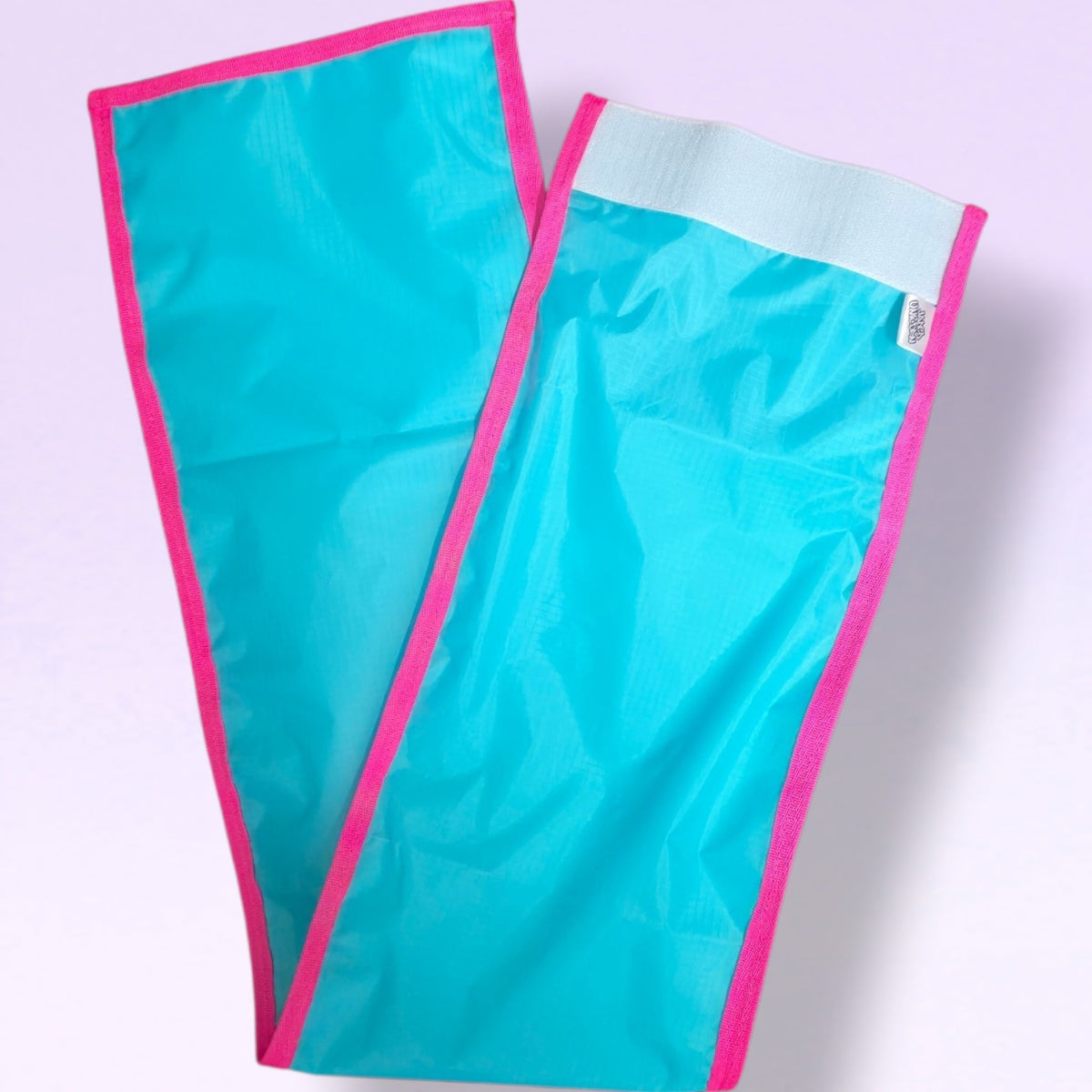 Picture of Rugged FeatherLite tail bag in colour Vivid Turquoise with Vivid Pink trim on a light purple background